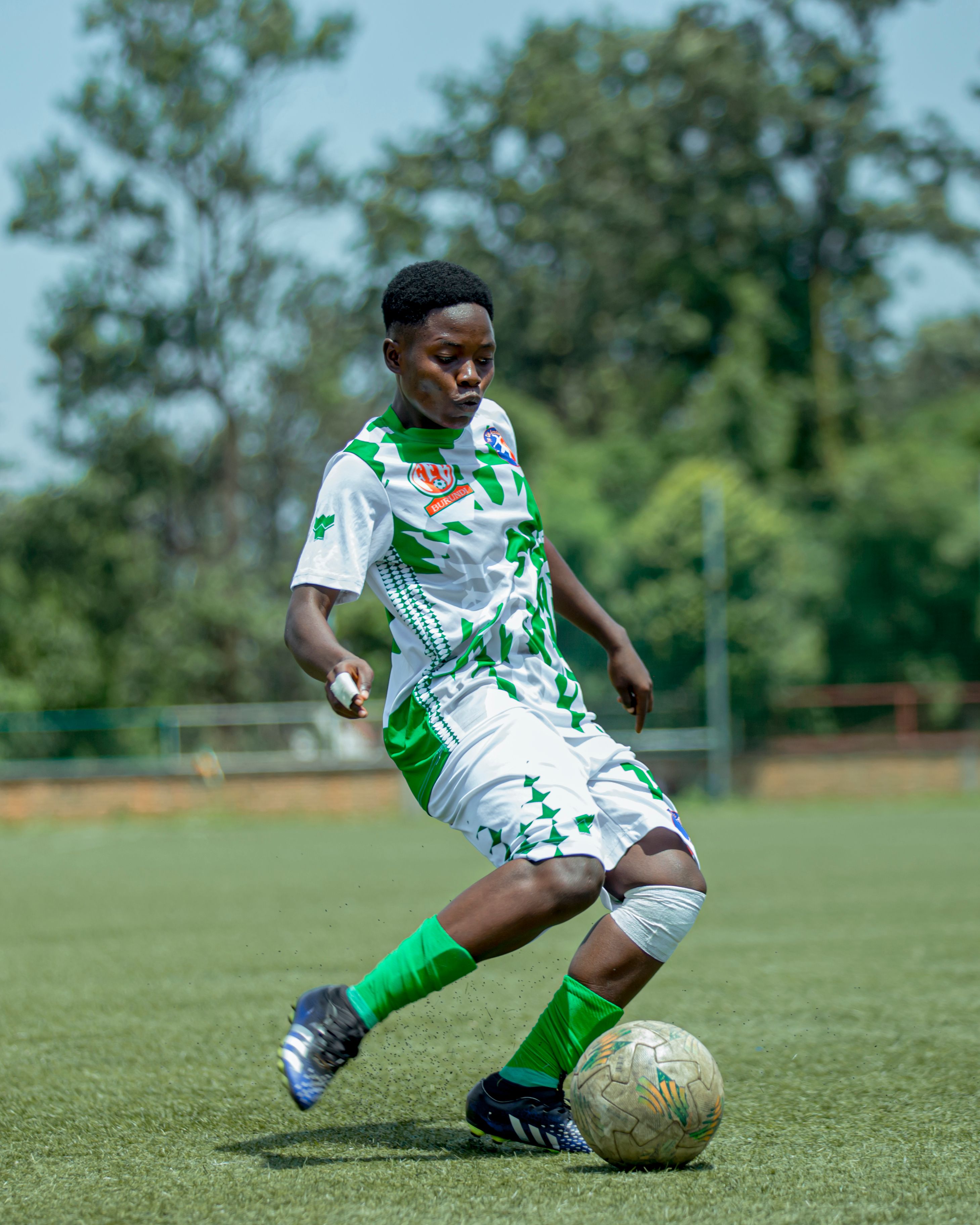 A young footballer controls the ball during a match